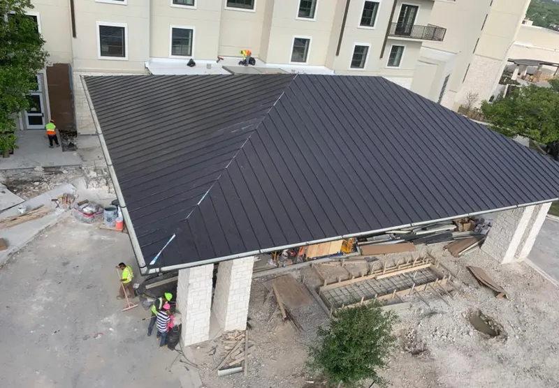 Metal roofing installation team working on a commercial building in Brookhaven